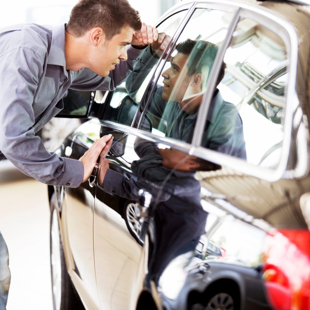 Young man admiring a new car